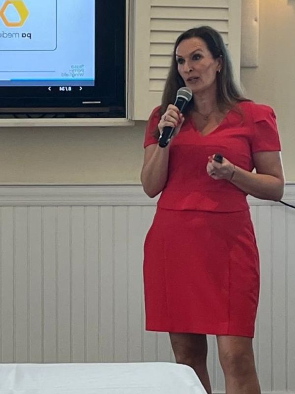 Tessa Parry-Wingfield speaking in a red dress